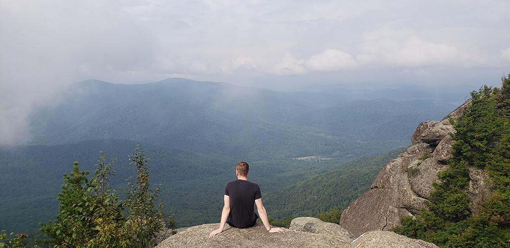 A man enjoyinng the view onn a mountain